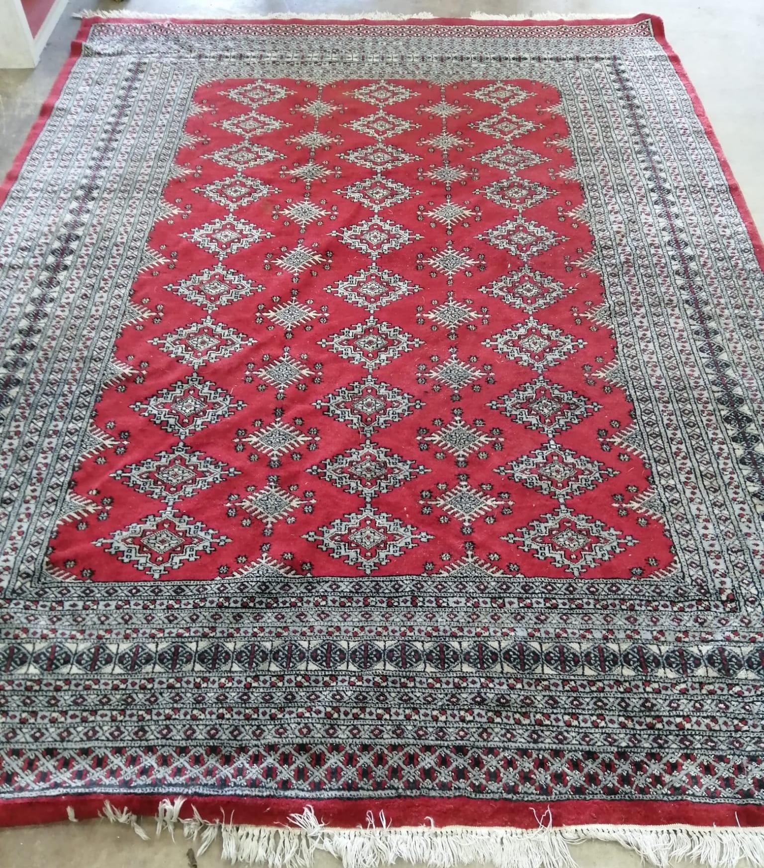 An Afghan red ground carpet, 290 x 210cm